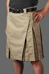 Person wearing a khaki kilt with a black belt on a gray background
